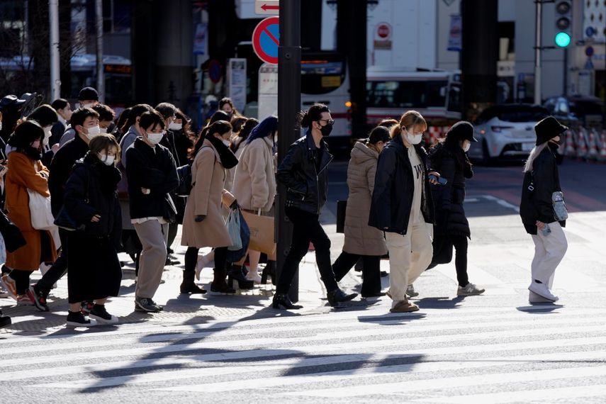 Unas personas portan mascarillas para frenar la propagación del coronavirus en un cruce peatonal el viernes 21 de enero de 2022, en Tokio