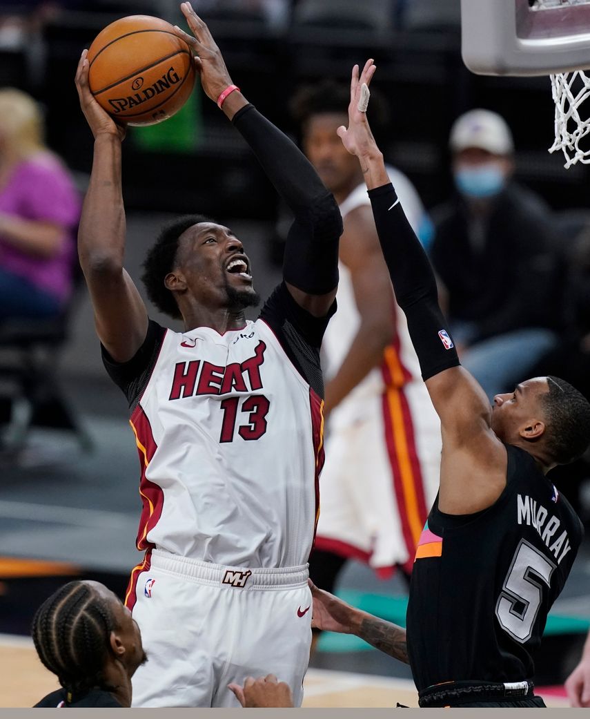 Bam Adebayo (13), del Heat de Miami, busca la canasta sobre Dejounte Murray (5), de los Spurs de San Antonio, en la segunda mitad del partido de la NBA en San Antonio, el miércoles 21 de abril de 2021