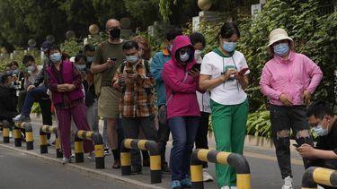 Vecinos con mascarillas hacen fila para hacerse pruebas de COVID-19 en el distrito de Chaoyang, el lunes 25 de abril de 2022 en Beijing.&nbsp;