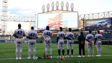 Jugadores de los Atléticos durante el himno nacional antes de un juego contra los Medias Blancas de Chicago en el Rate Field, el 15 de abril de 2025 en Chicago, Illinois.