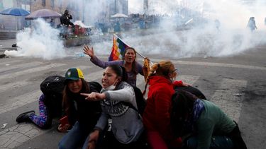 Manifestantes a favor del expresidente boliviano Evo Morales se protegen de las nubes de gas lacrim&oacute;geno lanzado por la polic&iacute;a, en La Paz, Bolivia, el 15 de noviembre de 2019.&nbsp;