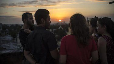 Marcos Marzo, segundo desde la izquierda, habla con sus amigos que vinieron a despedirse de él luego de recibir la noticia de que obtuvo un permiso para viajar a Estados Unidos, en La Habana, Cuba, el miércoles 25 de enero de 2023.&nbsp;