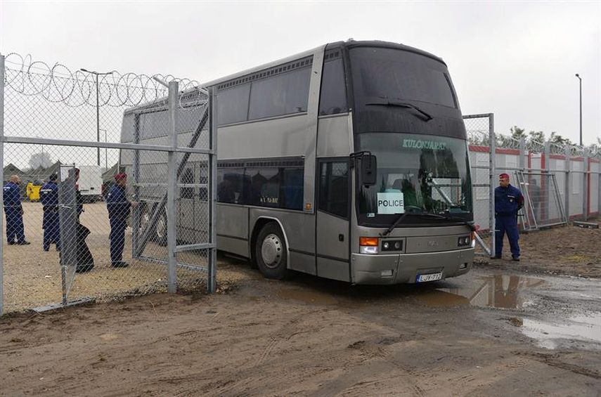 Refugiados suben a un autobús en un punto de registro en Roszke en la frontera Serbia con Hungría (EFE)