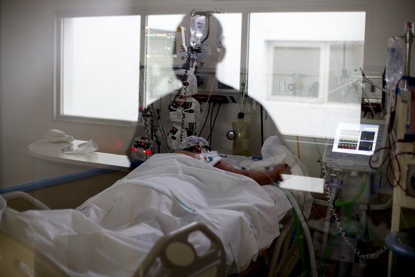 En esta imagen, tomada el 15 de septiembre de 2020, la imagen de una enfermera de cuidados intensivos se refleja en una ventana mientras observa a un paciente con COVID-19, en el hospital El Cruce Dr. Néstor Carlos Kirchner, en las afueras de Buenos Aires, Argentina.&nbsp;