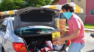 Jóvenes voluntarios ayudan a repartir alimentos a necesitados en Miami-Dade.