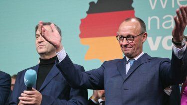 Friedrich Merz (d), líder de la conservadora Unión Cristianodemócrata (CDU) de Alemania y principal candidato de su partido a la cancillería, reacciona junto al primer ministro del estado de Baviera y líder de la conservadora Unión Social Cristiana (CSU), Markus Soeder, después de que se anunciaran en la televisión las primeras encuestas a pie de urna en las elecciones generales alemanas durante la noche electoral en Berlín el 23 de febrero de 2025.