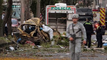Un agente de policía en Colombia inspecciona los restos de un vehículo en el lugar donde explotó una bomba en Cali, Colombia, el 21 de agosto de 2025, en otro hecho de violencia. Cinco personas murieron y decenas resultaron heridas.  
