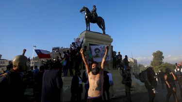 Un manifestante contra el gobierno levanta los brazos en la Plaza Italia después de un plebiscito para decidir si el país debe reemplazar su constitución de hace 40 años, redactada durante la última dictadura militar, en Santiago, Chile, el domingo 25 de octubre de 2020.