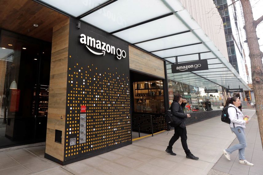 Varias personas salen de una tienda Amazon Go en Seattle. Amazon dijo que aplica su tecnología de pago con la mano en algunos de sus supermercados Whole Foods.
