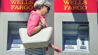 Una mujer pasa frente a un cajero automático de Wells Fargo.