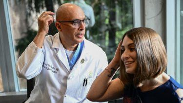 El Dr. Ahmed Raslan, profesor de cirugía neurológica, habla sobre la colocación de un implante cerebral con la paciente Amber Pearson, quien recibió el implante para tratar su epilepsia y su trastorno obsesivo-compulsivo (TOC), en el hospital de la Universidad de Ciencias y Salud de Oregón (OHSU). en Portland, Oregón.