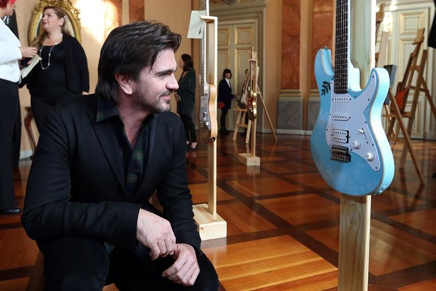 Juanes observa la guitarra intervenida de su compatriota Calos Vives (EFE)