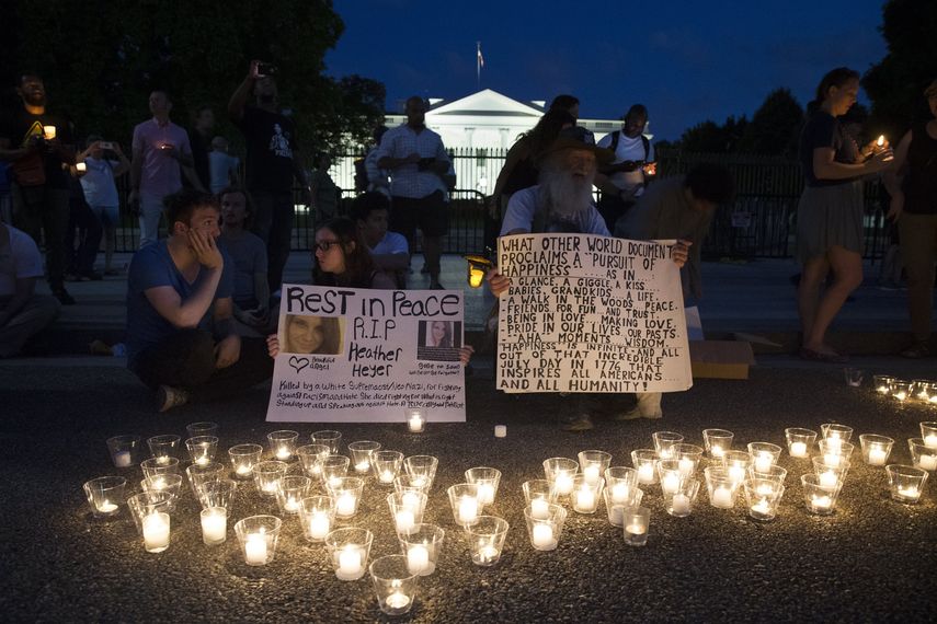 La gente participa en una vigilia a la luz de las velas en la avenida Pennsylvania, frente a la Casa Blanca, para mostrar solidaridad con las víctimas de la violencia que tuvo lugar este fin de semana en un mitin blanco nacionalista en Charlottesville, Virginia.