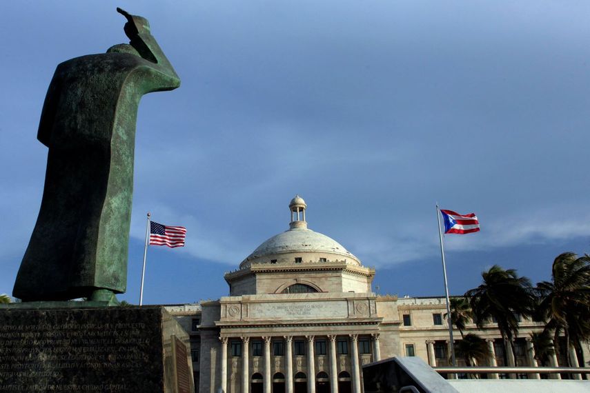 &nbsp;Una estatua de bronce de San Juan Bautista frente al Capitolio, flanqueada por banderas de Estados Unidos y Puerto Rico, en San Juan, Puerto Rico.&nbsp;