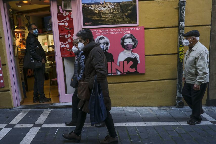 Unas personas con cubrebocas debido al coronavirus caminan por una calle en Pamplona, norte de España, el 20 de noviembre de 2020.
