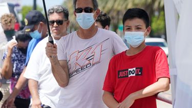 Agustin Cortez, de 13 años, y su tío, Luis Cortez, aguardan a que Agustin se haga una prueba diagnóstica de COVID-19, en North Miami, Florida.&nbsp;