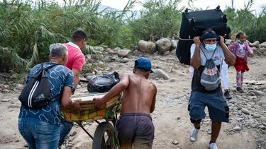 Venezolanos empujan un carro cargado de compras hacia Venezuela a través de las llamadas trochas - senderos ilegales- en Cúcuta, los cuales también siempre han estado minados por el contrabando.