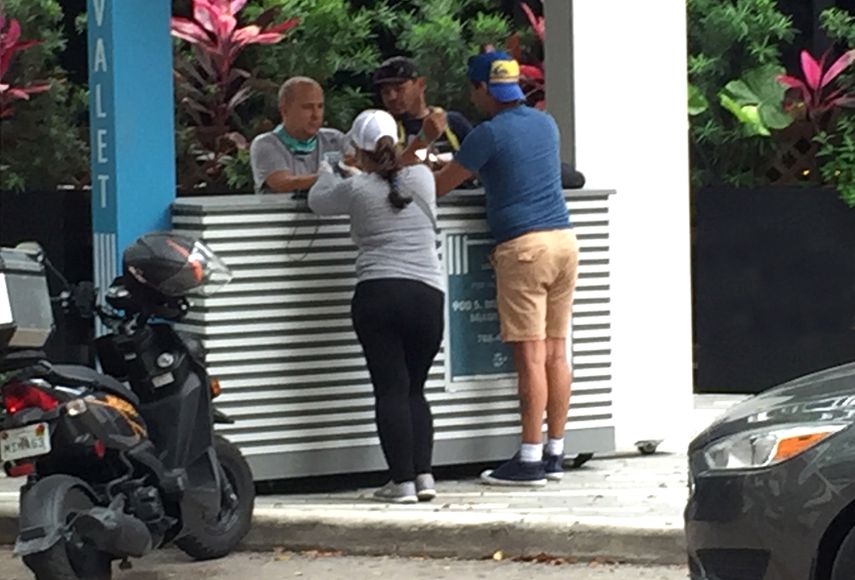 Un grupo de personas conversa en Miami a pesar de las medidas de distancia y protecci&oacute;n.