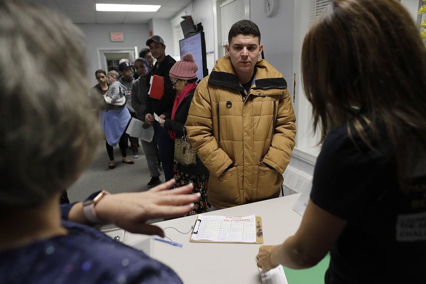 Esta fotograf&iacute;a muestra al brasile&ntilde;o Helison Alvarenga, al centro, hablando con las voluntarias Marcia Previatti, en primer plano a la izquierda, y Arlene Vilela, en primer plano a la derecha, en el Centro Comunitario Nueva Inglaterra en Stoughton, Massachussets.&nbsp;