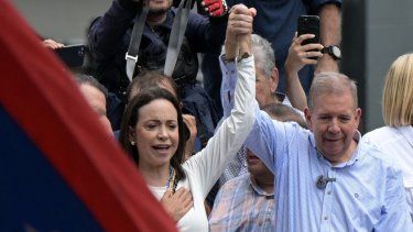 La líder opositora venezolana María Corina Machado levanta la mano de Edmundo González Urrutia durante una manifestación frente a la sede de las Naciones Unidas en Caracas el 30 de julio de 2024.