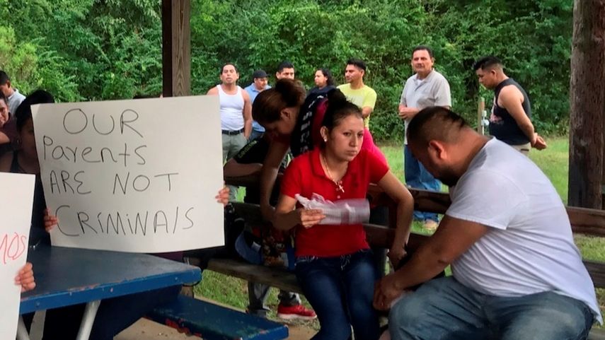 Nuestros padres no son criminales, dice un cartel que un grupo de personas sostiene en protesta por las políticas antiinmigrantes en Mississippi, el 13 de agosto del 2019.