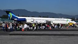 Migrantes guatemaltecos deportados de Estados Unidos caminan por la pista tras llegar a la Base de la Fuerza Aérea Guatemalteca en Ciudad de Guatemala el 27 de diciembre de 2024, durante el último vuelo de deportados del año. Migrantes guatemaltecos deportados de Estados Unidos caminan por la pista tras llegar a la Base de la Fuerza Aérea Guatemalteca en Ciudad de Guatemala el 27 de diciembre de 2024, durante el último vuelo de deportados del año.