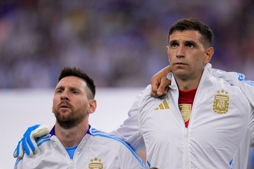 El delantero argentino Lionel Messi (izquierda) y el arquero Emiliano Martínez durante la ceremonia de himnos previo al partido contra Ecuador por los cuartos de final de la Copa América, el jueves 4 de julio de 2024, en Houston.