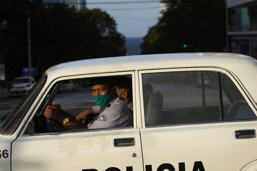 Agentes de polic&iacute;a con m&aacute;scaras como precauci&oacute;n contra la propagaci&oacute;n del nuevo coronavirus conducen una patrulla en una calle vac&iacute;a durante el toque de queda en La Habana, Cuba, el martes 1 de septiembre de 2020.&nbsp;