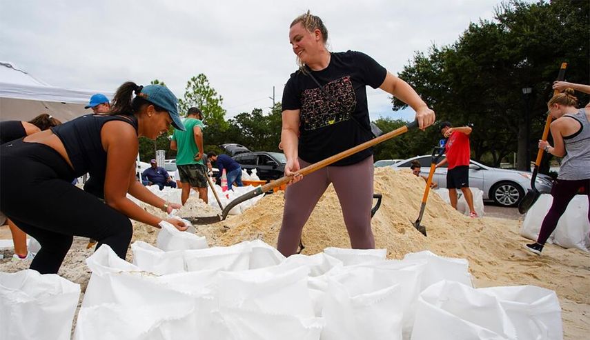 Vecinos de Tampa llenan sacos de arena.