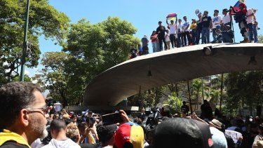 Personas sostienen banderas de Venezuela pidiendo la libertad de presos políticos este jueves, durante una marcha en el Día de la Juventud en Caracas (Venezuela).&nbsp; 