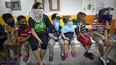 Varios niños observan una pequeña función teatral en la casa de una mujer que los asiste con las tareas escolares ahora que se imparte enseñanza a la distancia por el coronavirus en un barrio de Caracas.