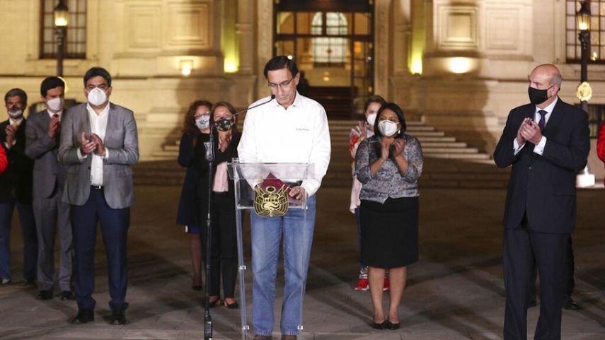 El presidente de Perú, Martín Vizcarra, baja la mirada mientras miembros de su gabinete lo aplauden frente al palacio presidencia en Lima, después de que el Congreso aprobó su destitución el lunes 9 de noviembre de 2020