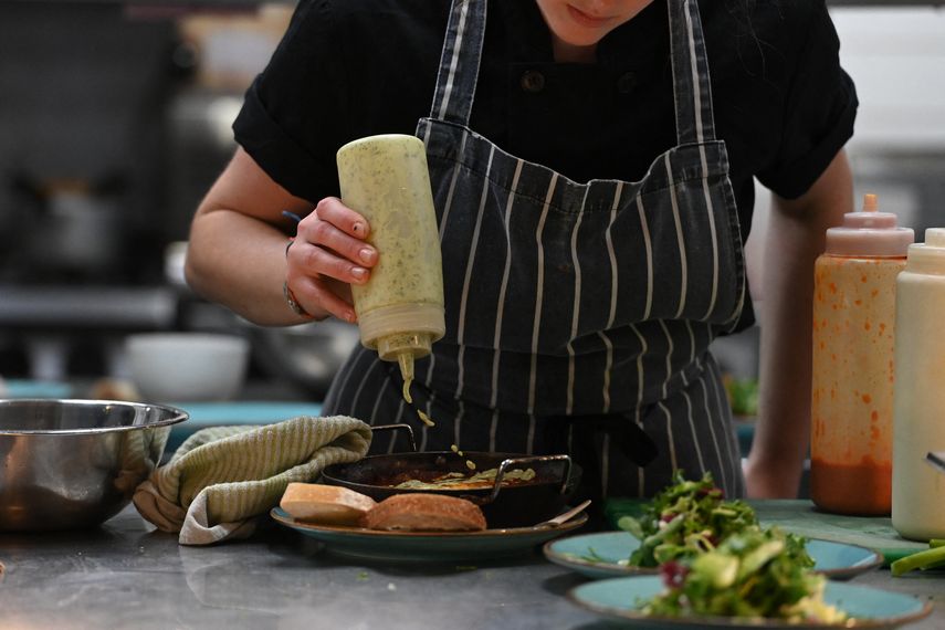 Un miembro del personal prepara algo de comida en el restaurante The Canteen, uno de los primeros en el Reino Unido en incluir la huella de carbono de sus platos en su menú además de las calorías, en Bristol, el 3 de agosto de 2022.