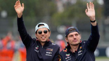 El piloto de Red Bull, Max Verstappen (derecha), y su compañero Sergio Pérez saludan al público en el Autódromo Hermanos Rodríguez de la Ciudad de México previo al Gran Premio de México, el domingo 27 de octubre de 2024.