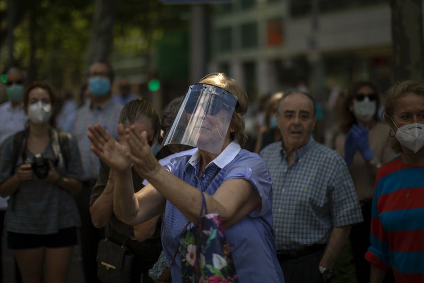 Gente aplaude a los participantes de una marcha de protesta organizada por el partido Vox contra la pol&iacute;tica del gobierno espa&ntilde;ol para la pandemia de coronavirus, en Barcelona, Espa&ntilde;a, s&aacute;bado 23 de mayo de 2020.&nbsp;