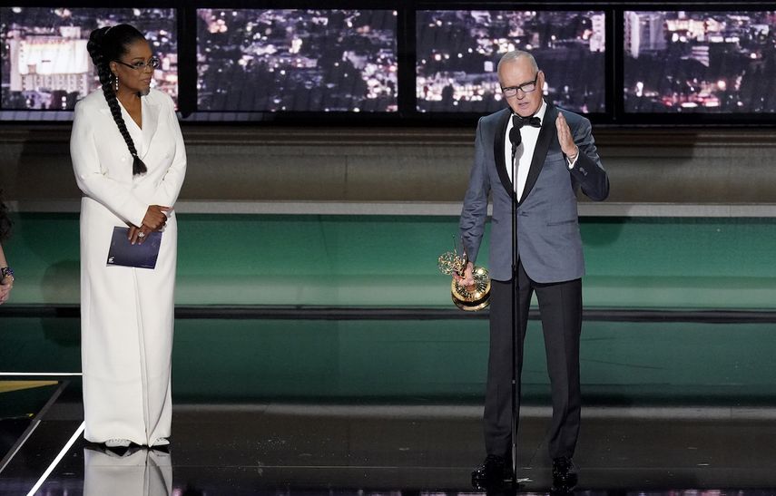 Michael Keaton, derecha, recibe el Emmy a mejor actor en una serie limitada, antología o película para televisión por Dopesick acompañado por la presentadora Oprah Winfrey en la 74a entrega de los Premios Emmy el lunes 12 de septiembre de 2022 en el Teatro Microsoft en Los Angeles. Lista de ganadores de los Emmy.