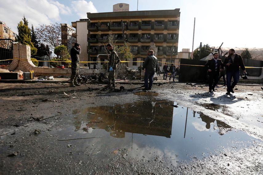 Varios agentes de policía inspeccionan el lugar de un atentado en Siria.