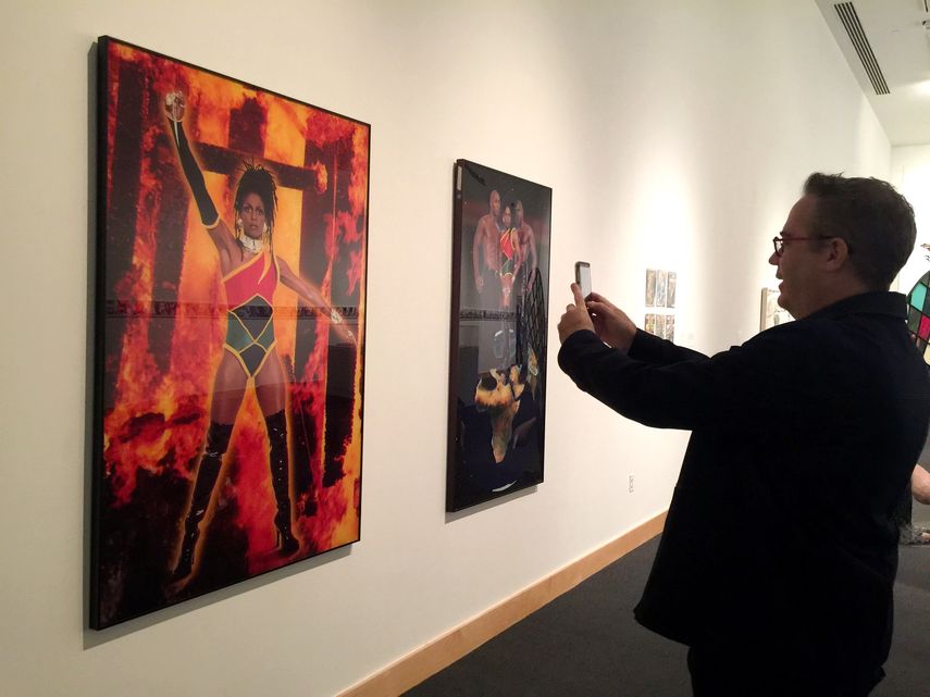 Un hombre fotografía una obra de Renèe Cox, la artista jamaicana que se autorretrata convertida en la antiheroina Raje, durante su visita a la muestra Beyond&nbsp;the&nbsp;Cape. Comics and Contemporay Art