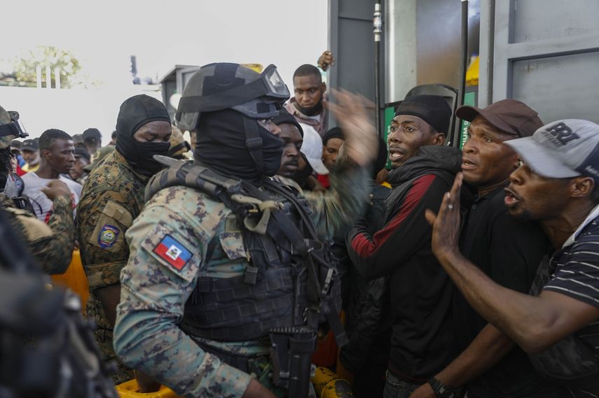 Agentes de la policía tratan de controlar a una multitud que intenta obtener combustible en una gasolinera de Puerto Príncipe, Haití, el jueves 4 de noviembre de 2021.&nbsp;