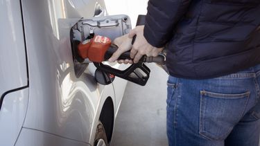 Una persona rellena su auto de combustible.