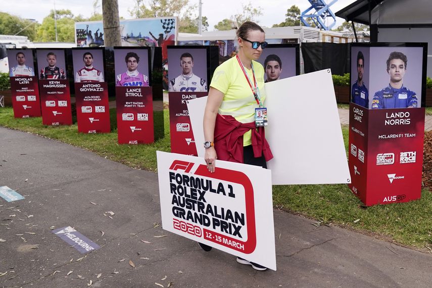 Una mujer retira carteles tras la cancelaci&oacute;n del Gran Premio de Australia de F&oacute;rmula&nbsp;1 en Melbourne el viernes, 1 de marzo del 2020, debido al brote de coronavirus.&nbsp;