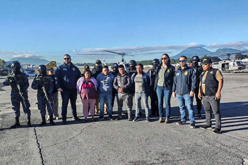 Agentes de policía escoltando a los detenidos a su llegada al aeropuerto de Ciudad de Guatemala el 9 de diciembre de 2024.