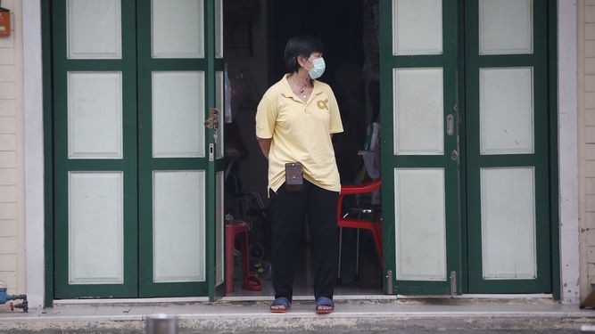 Una tendera con mascarilla para frenar los contagios de coronavirus ante su tienda en la calle Khao San, popular entre tailandeses y turistas en Bangkok, Tailandia, el lunes, 26 de abril de 2021.&nbsp;