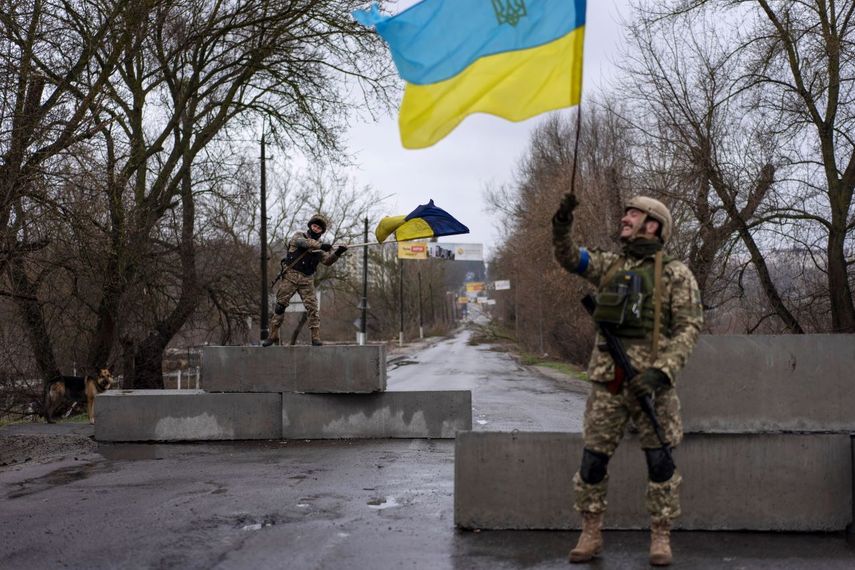 Un soldado ucraniano levanta una bandera de su país en Bucha, en las afueras de Kiev, el 3 de abril del 2022.&nbsp;