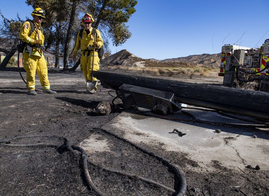 Bomberos de California examinan un poste de bajo voltaje calcinado en un incendio, el 25 de octubre de 2019, en Santa Clarita, California.&nbsp;