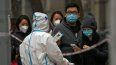 Un hombre muestra su código QR de control de salud mientras él y otras personas hacen fila para hacerse pruebas de rutina de COVID-19 en Pekín, China.