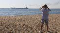 Un hombre hace una foto del carguero Glory a su salida del puerto de Odesa, Ucrania, el domingo 7 de agosto de 2022. 
