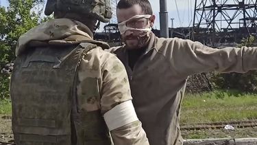 En esta imagen tomada de un video publicado por el servicio de prensa del Ministerio ruso de Defensa el miércoles 18 de mayo de 2022, un militar ruso registra a un soldado ucraniano después de que saliera de la asediada planta siderúrgica de Azovstal, en Mariúpol, Ucrania.&nbsp;