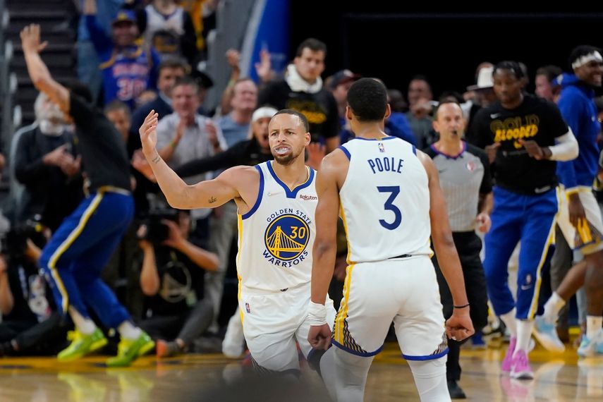 Stephen Curry (30), de los Warriors de Golden State, recibe la felicitación de su compañero Jordan Poole (3) tras anotar contra los Nuggets de Denver en la primera mitad del segundo juego de su serie de primera ronda del playoff en San Francisco, el 18 de abril de 2022.&nbsp;