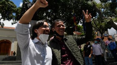 El recientemente indultado y liberado diputado opositor Gilber Caro (derecha) muestra el letrero de la Victoria junto al diputado opositor Freddy Guevara, mientras este &uacute;ltimo abandona la embajada de Chile donde se hab&iacute;a refugiado en 2017, en Caracas.